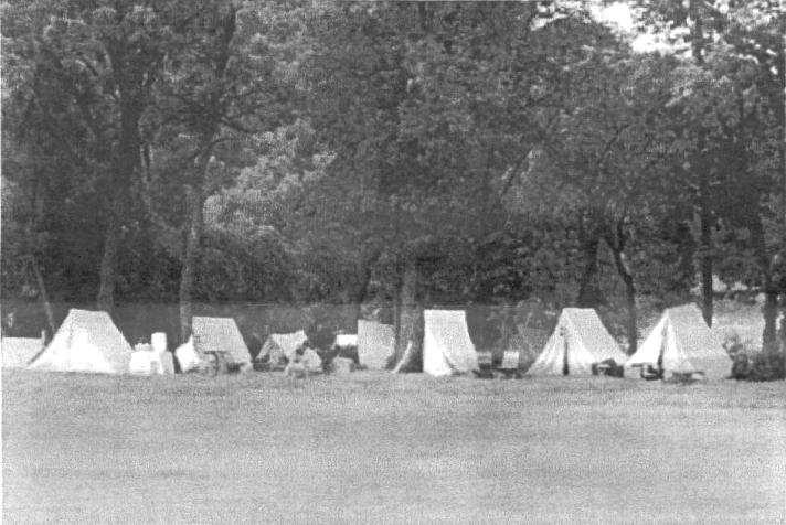 Long view of tents along the creek