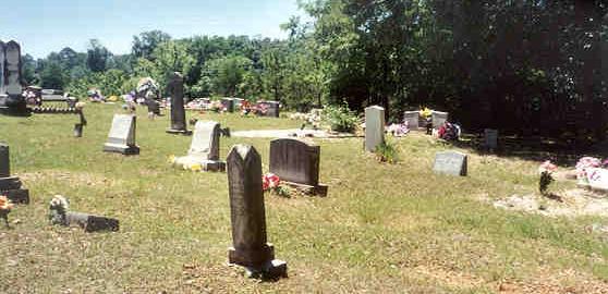 Stevan Hinson's headstone is the narrow column in the foreground. The flat one to the left with the white silk flower is another Beam.  The white pebble marked grave at the top of Stevan's grave is Rufus and Sarah Beams. Rufus father's headstone "Teeter" Beam is the gray tall flat headstone hear the left hand corner of Rufus and Sarah Beam's grave.