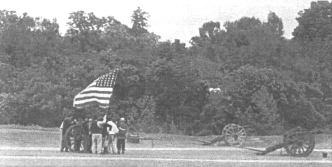 Group of men by cannon holding Union Flag